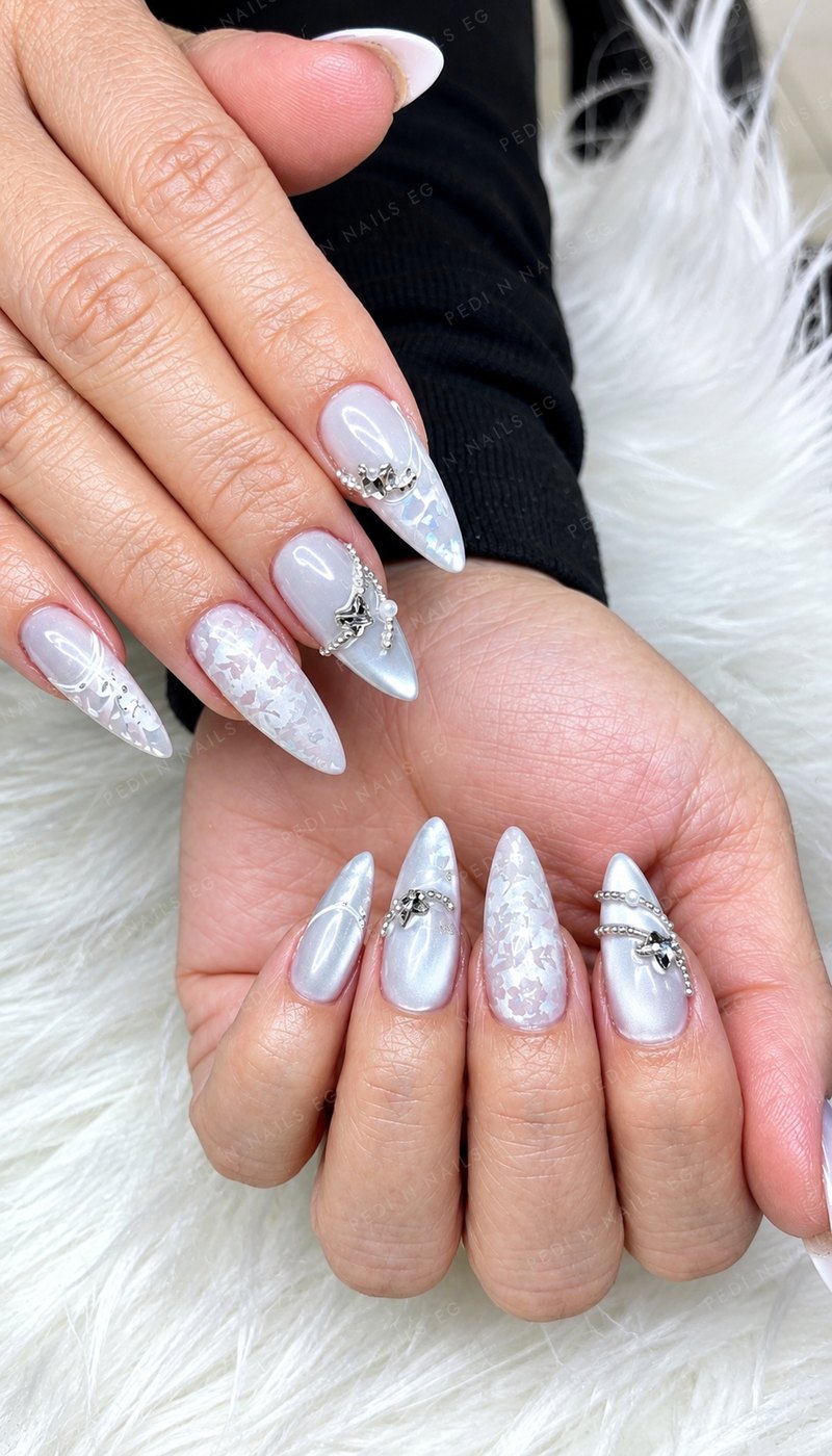 Pearl white chrome almond nails with silver star charms and floral accents